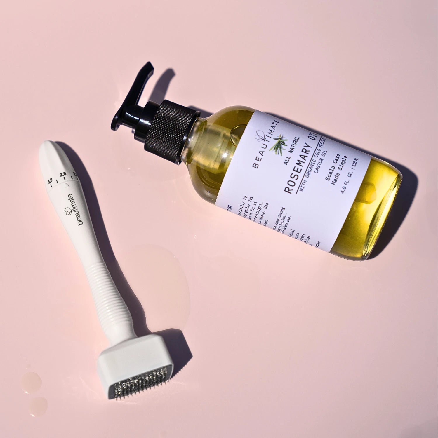 rosemary oil and micorneedle derma stamp on pink background