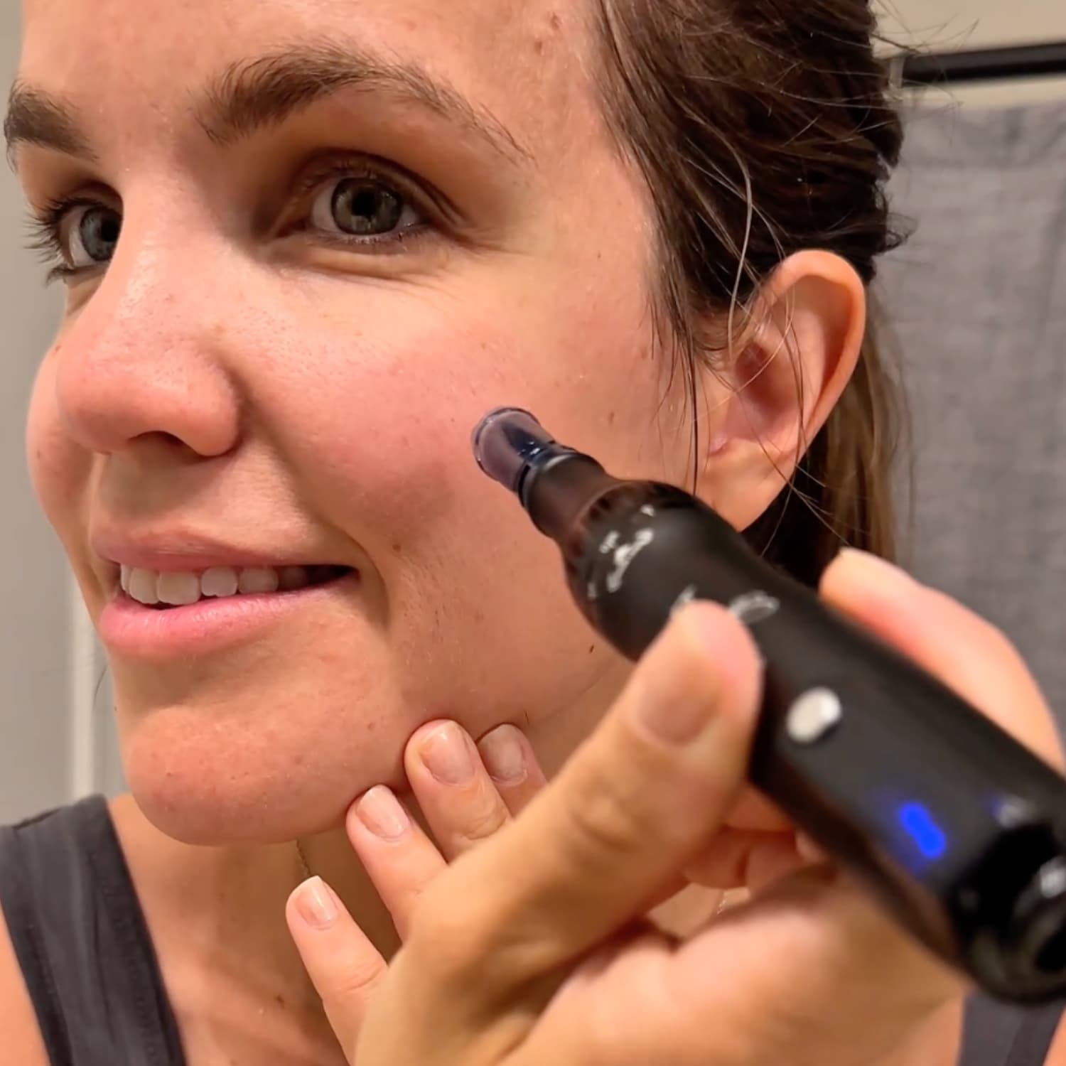 Woman using Beautimate microneedle pen on face at home