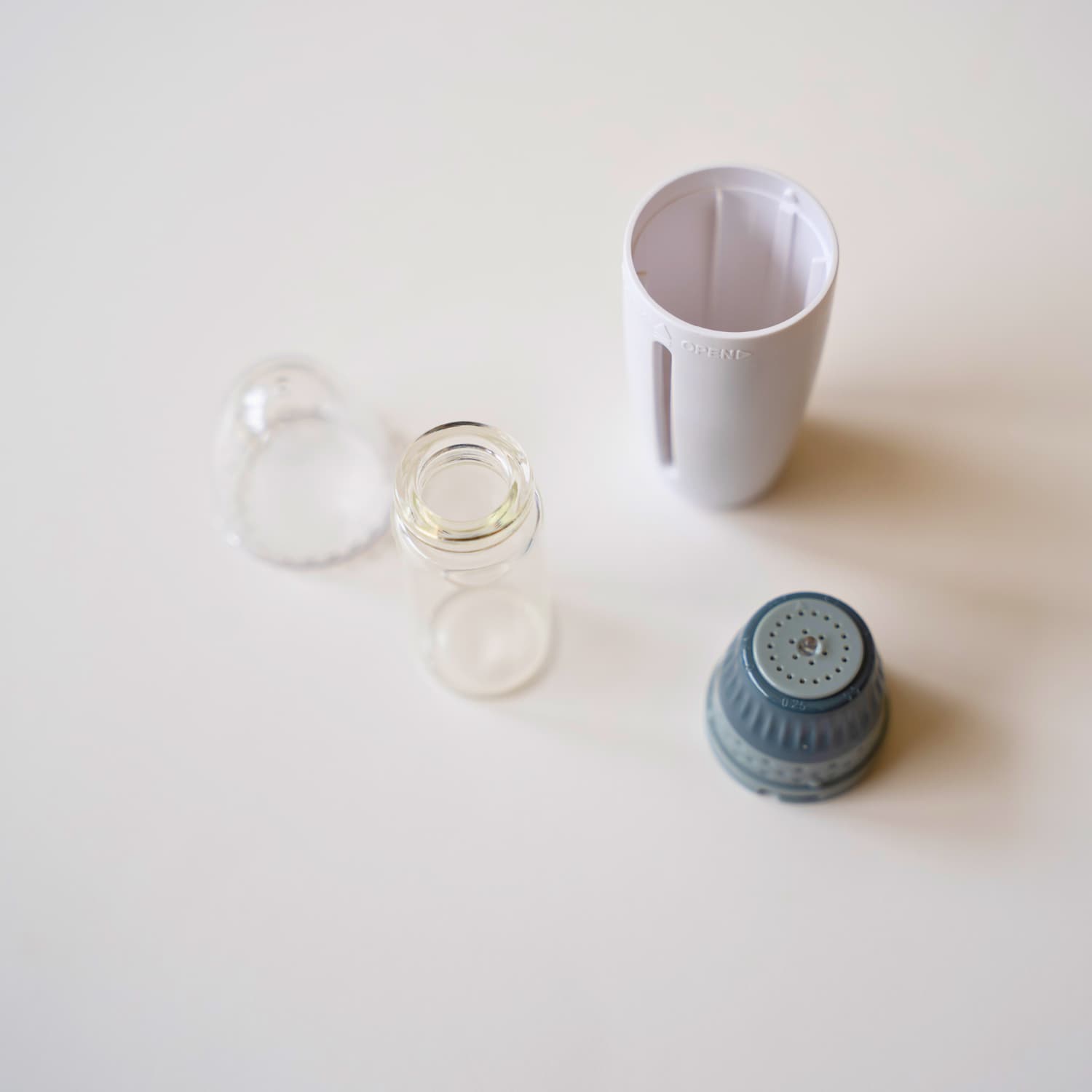 Beautimate Hydra Stamp disassembled to show refillable 10ml glass chamber and detachable microneedle head
