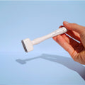 Hand holding a white beautimate derma stamp