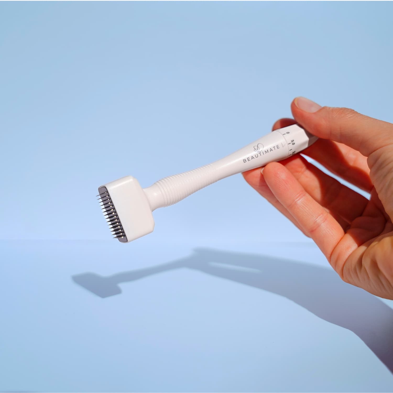 Hand holding a white beautimate derma stamp