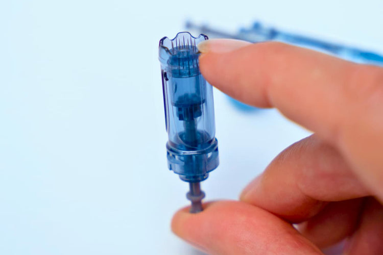 Hand holding Dr pen M8s cartridge against a light blue background
