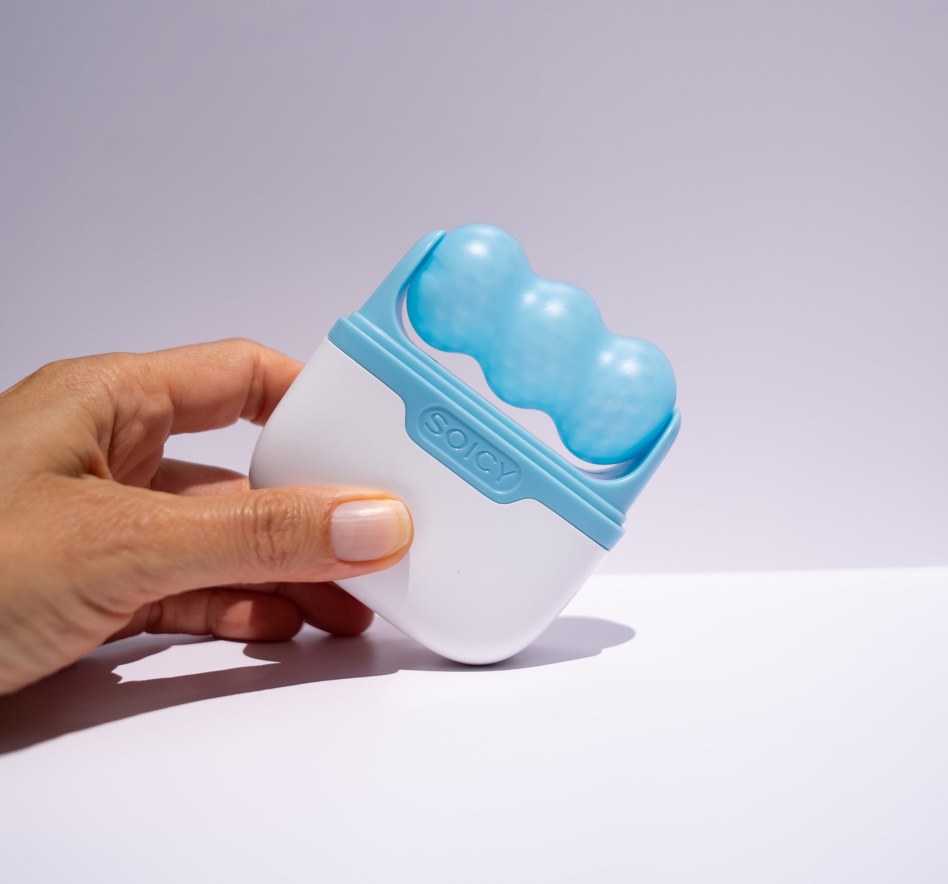 hand holding blue ice roller beautiamte