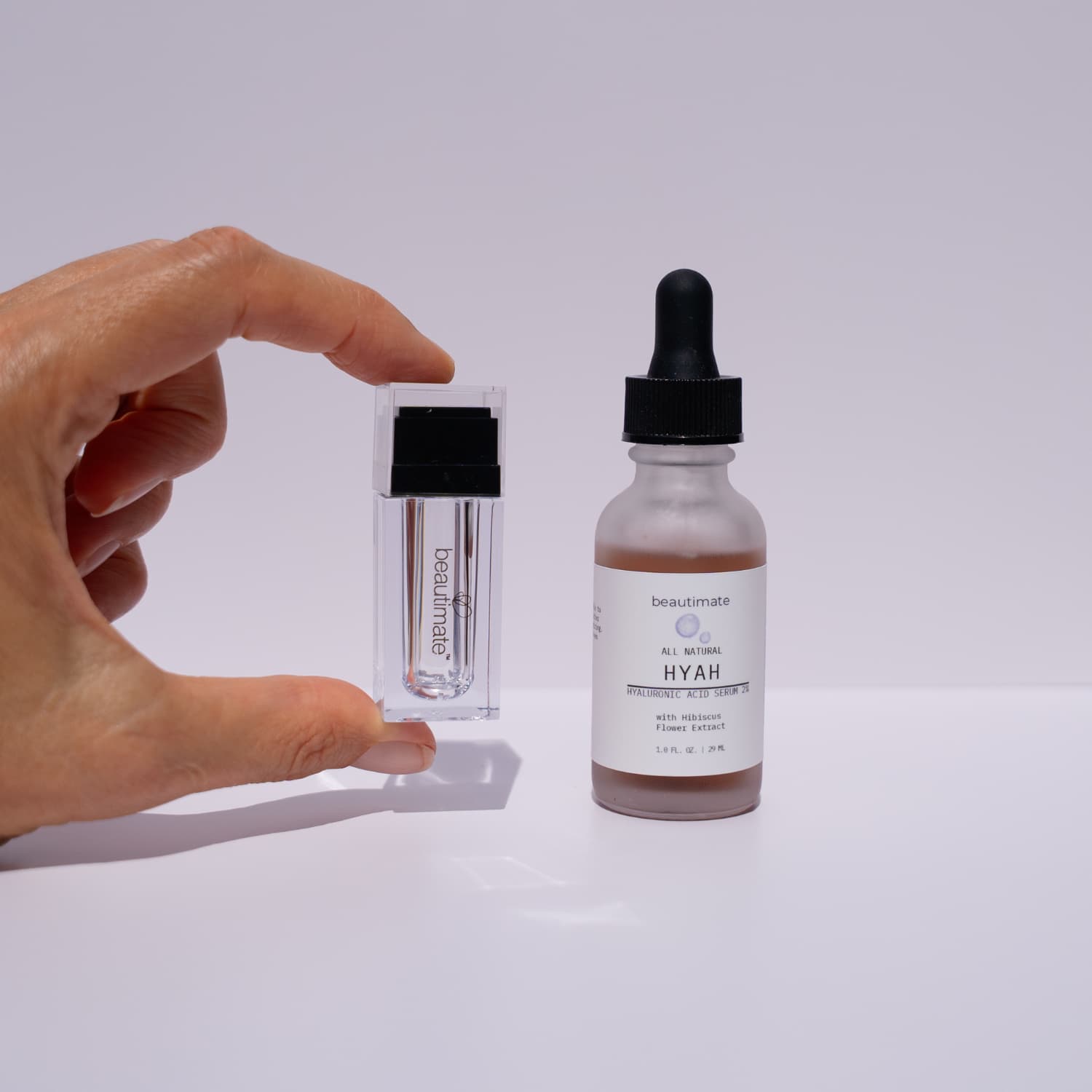 hand holiding hydra stamp with hyah serum next to it
