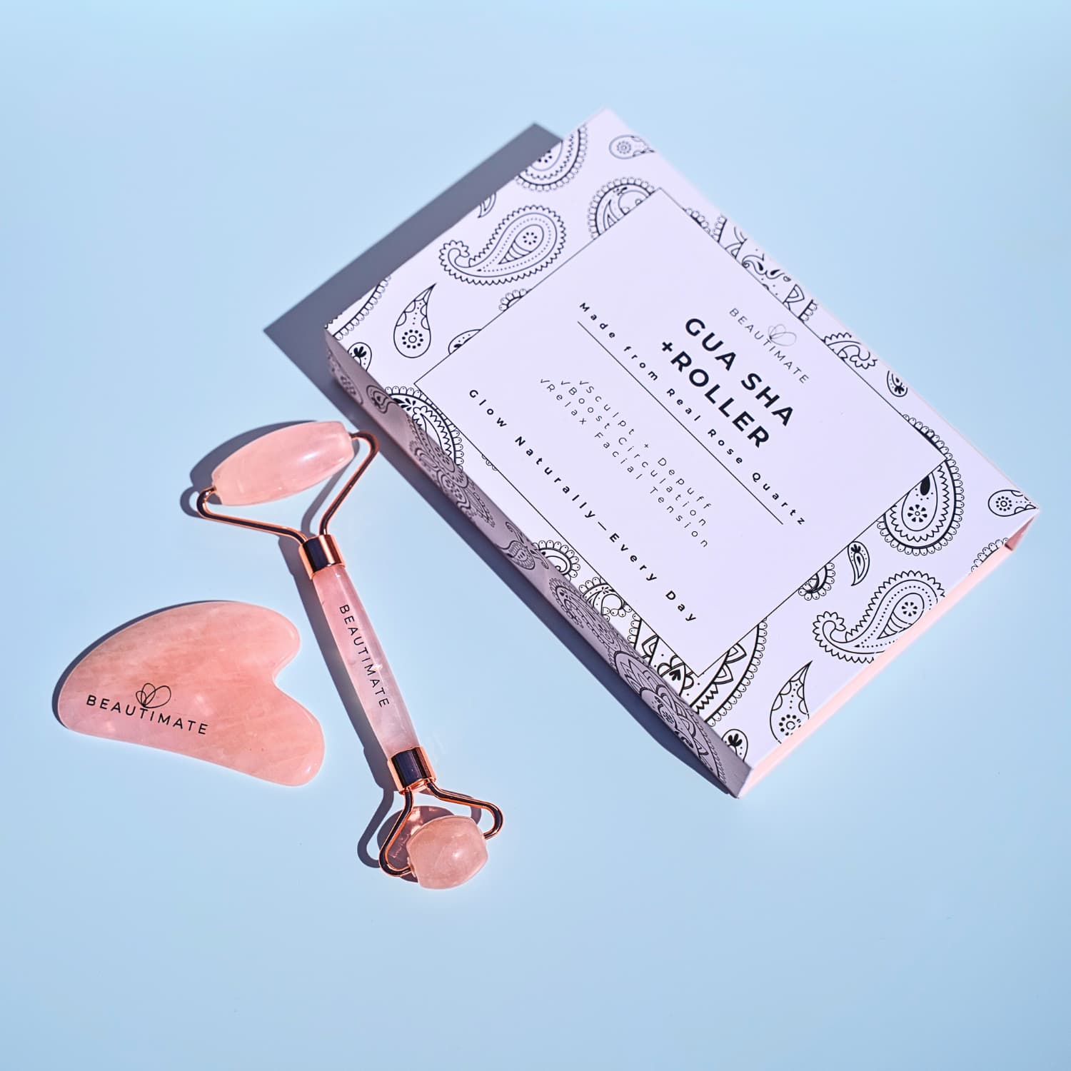 Beauty tool set with roller and gua sha on a light blue background