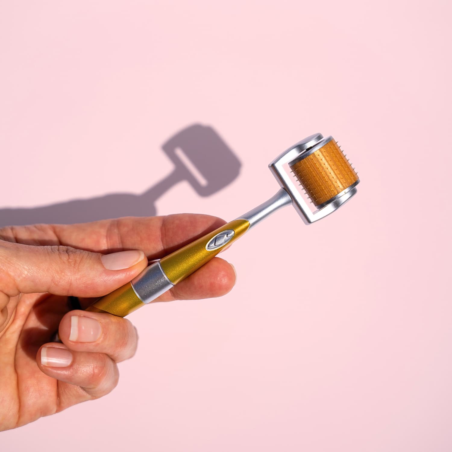 Hand holding At-home microneedling derma roller for glowing skin