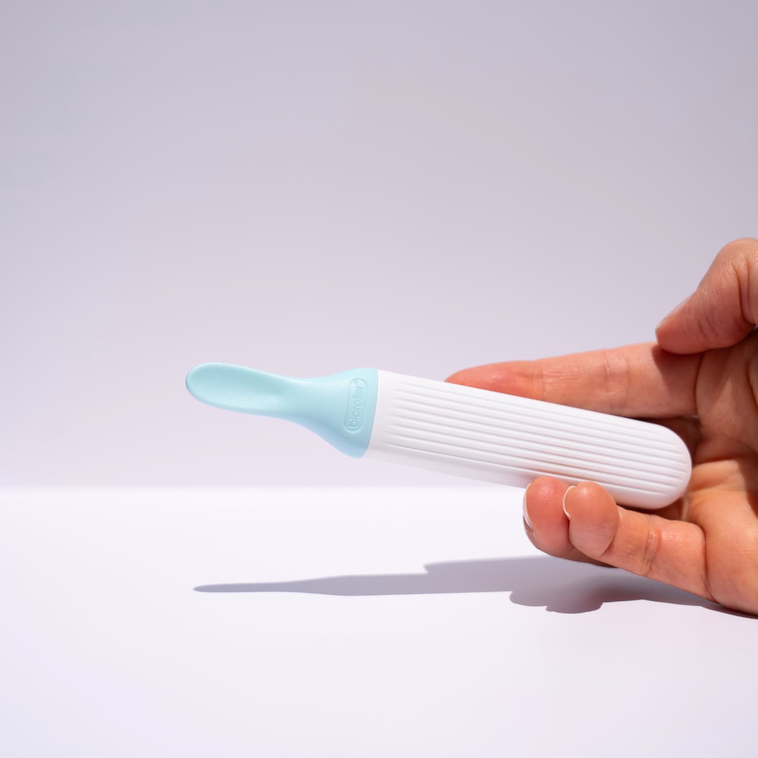 Hand holding a spatula to apply serums 