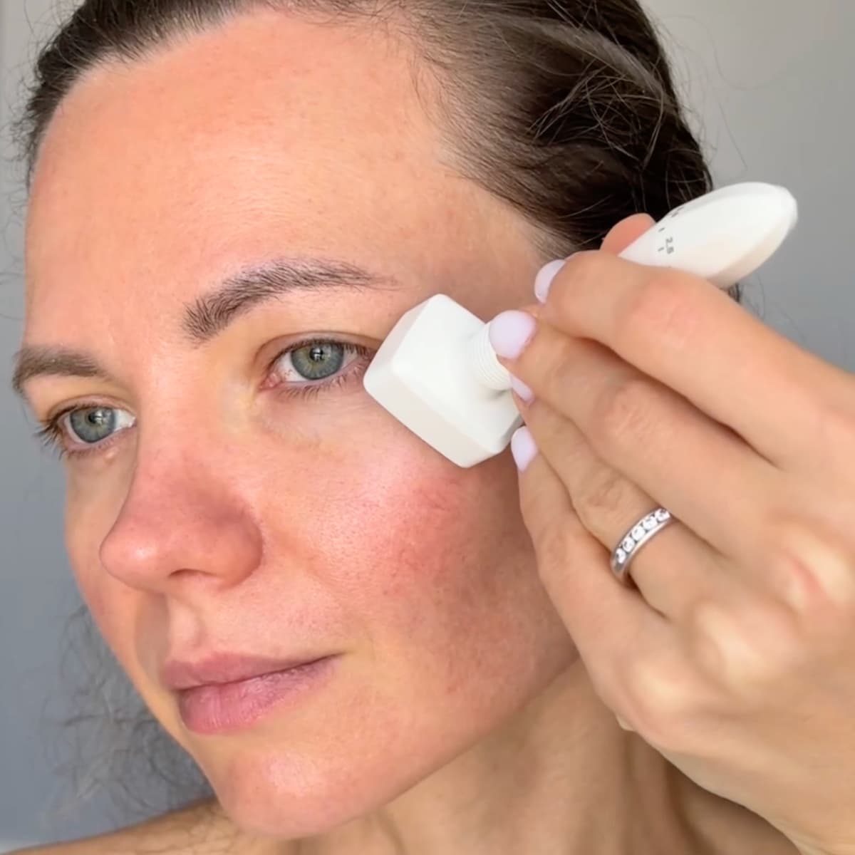 Woman using Beautimate Adjustable Derma Stamp on face to improve fine lines and skin tone